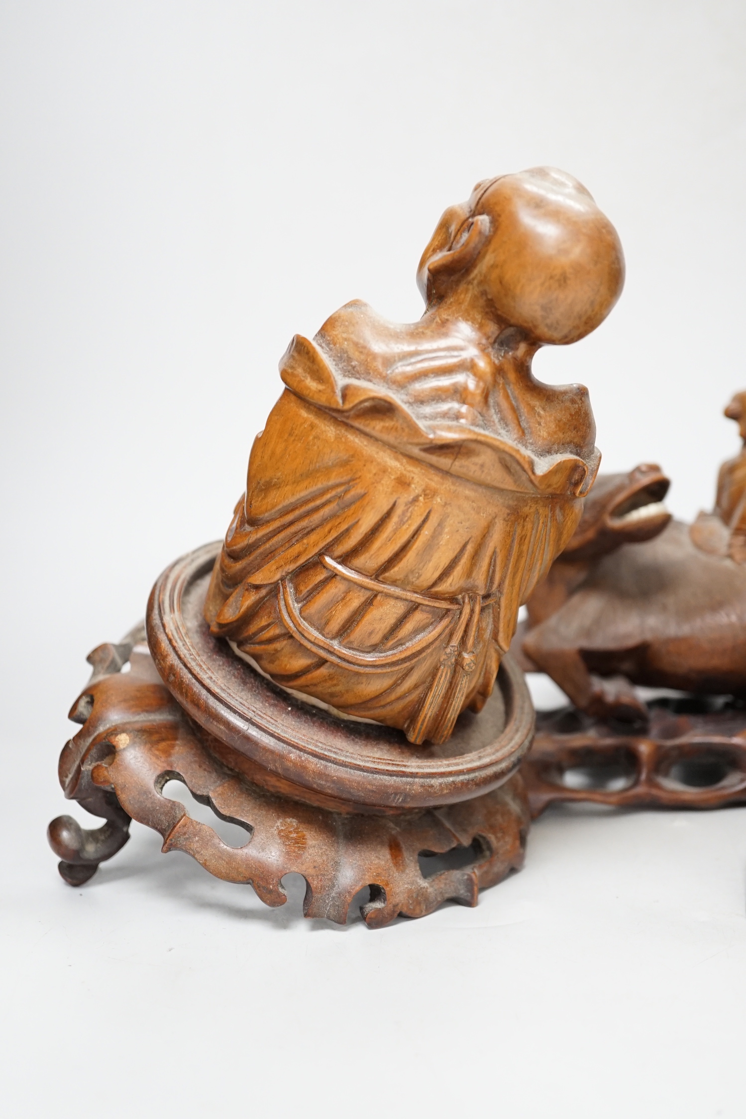 A pair of Chinese carved hardwood buffalo carvings, and a similar figure of a luohan, latter 24cm - damaged